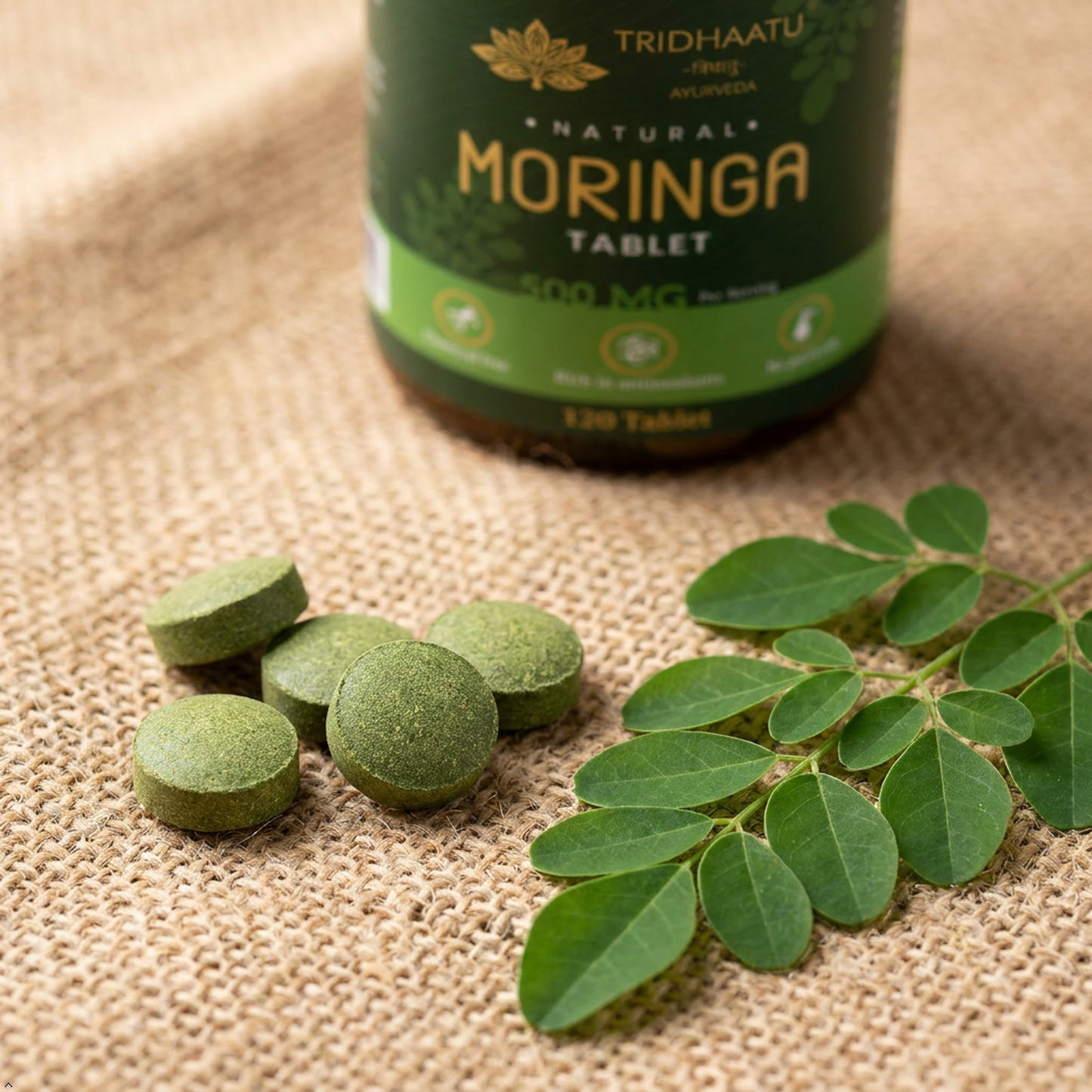 Moringa tablets and leaves with a bottle labeled 'Tridhaatu' on a textured surface
