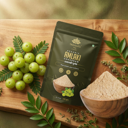 Tribhuvan Organic Amlaki Chodiram packaging with amlaki fruits and powder on a wooden board.